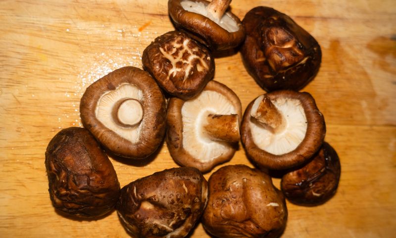 Fresh shiitake mushrooms on a wooden cutting board